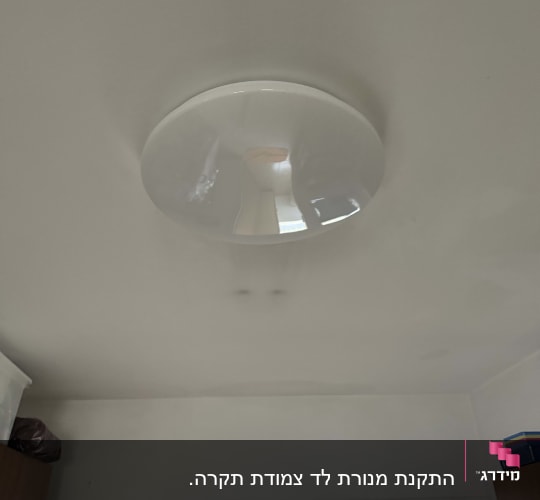 מנורת תקרה עגולה מותקנת על תקרה לבנה
